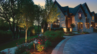 An opulent house gently illuminated with accent and path lights.