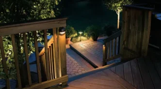 Half moon deck light attached to a wooden patio fence.