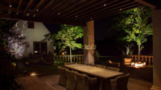 Residential outdoor dining area adorned by landscape lights.