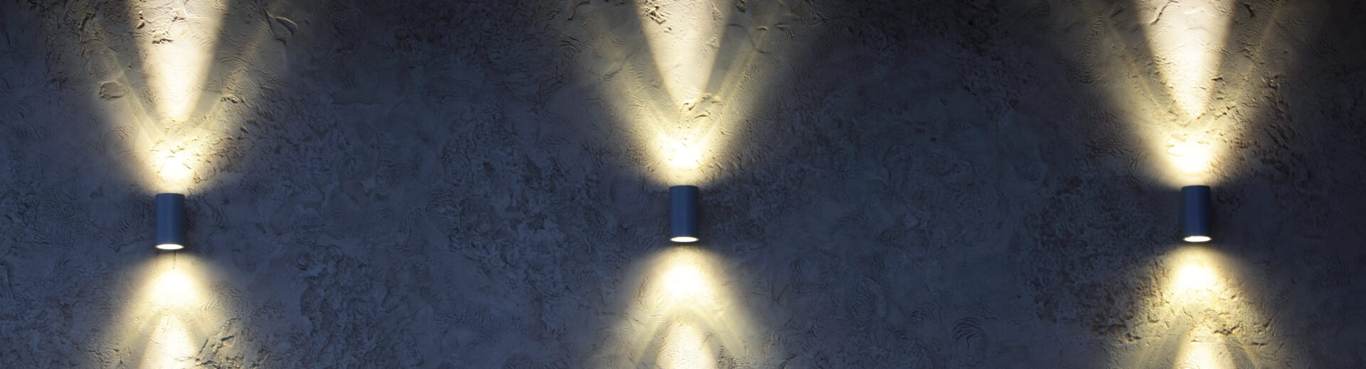 Up and down sconce lights illuminating a retaining wall vertically.