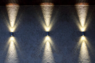 Up and down sconce lights illuminating a retaining wall vertically.