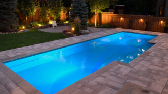 Backyard with accent lights and path lights strategically positioned around a swimming pool area.