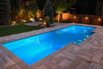 Backyard with accent lights and path lights strategically positioned around a swimming pool area.