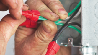 Person connecting wires with red king innovation wire nut connectors.