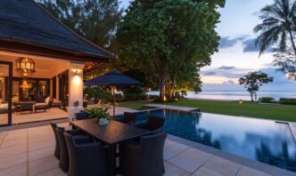 Elegant outdoor dining area by a pool at sunset near the beach.