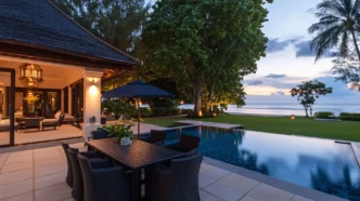 Elegant outdoor dining area by a pool at sunset near the beach.