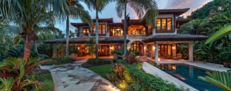 Tropical paradise with lush landscaping, palm trees, and outdoor lighting.