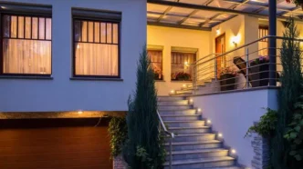 Front porch of modern house with wall lights aligning and illuminating each step.