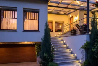 Front porch of modern house with wall lights aligning and illuminating each step.