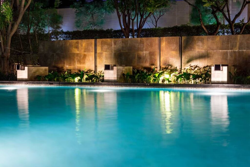 Pool-adjacent retaining wall illuminated by wall wash lighting. 