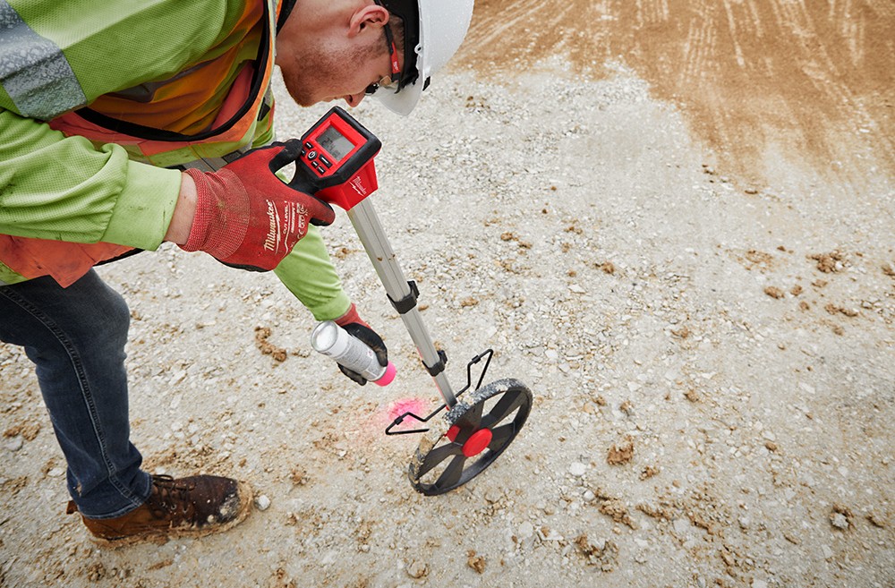 Electrician using milwaukee digital measuring wheel to measure wire runs.