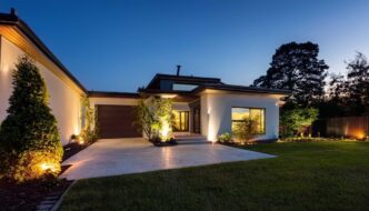 Beautiful middle class home at dusk illuminated by landscape lights.