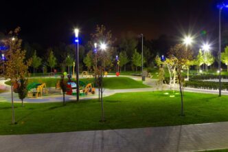 Lights shining throughout a playground adorned with colorful slides and amenities at night.