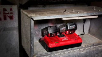 Milwaukee Dual Rapid Charger charging two Milwaukee Tool batteries on a work shelf.