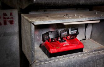 Milwaukee Dual Rapid Charger charging two Milwaukee Tool batteries on a work shelf.