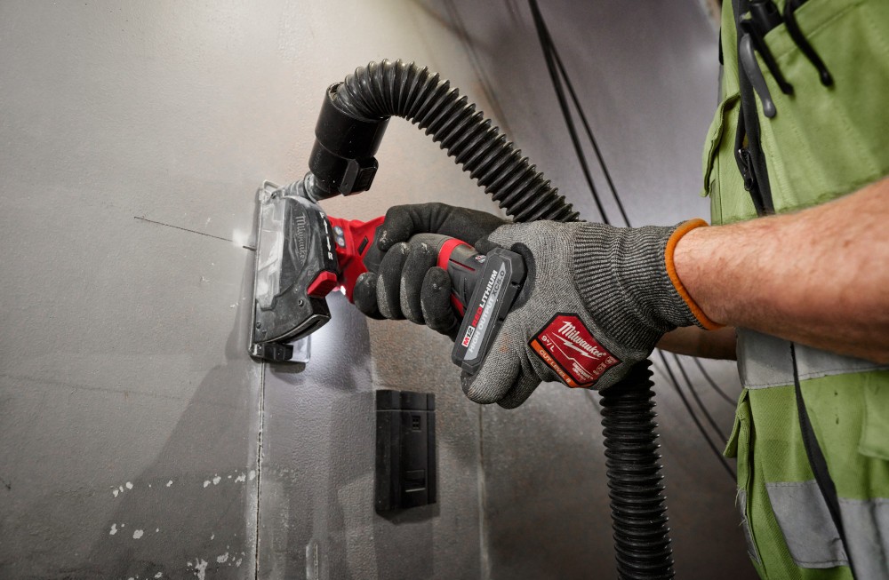 A Milwaukee saw, powered by a Milwaukee High Output battery, cutting through a wall for wire installation.