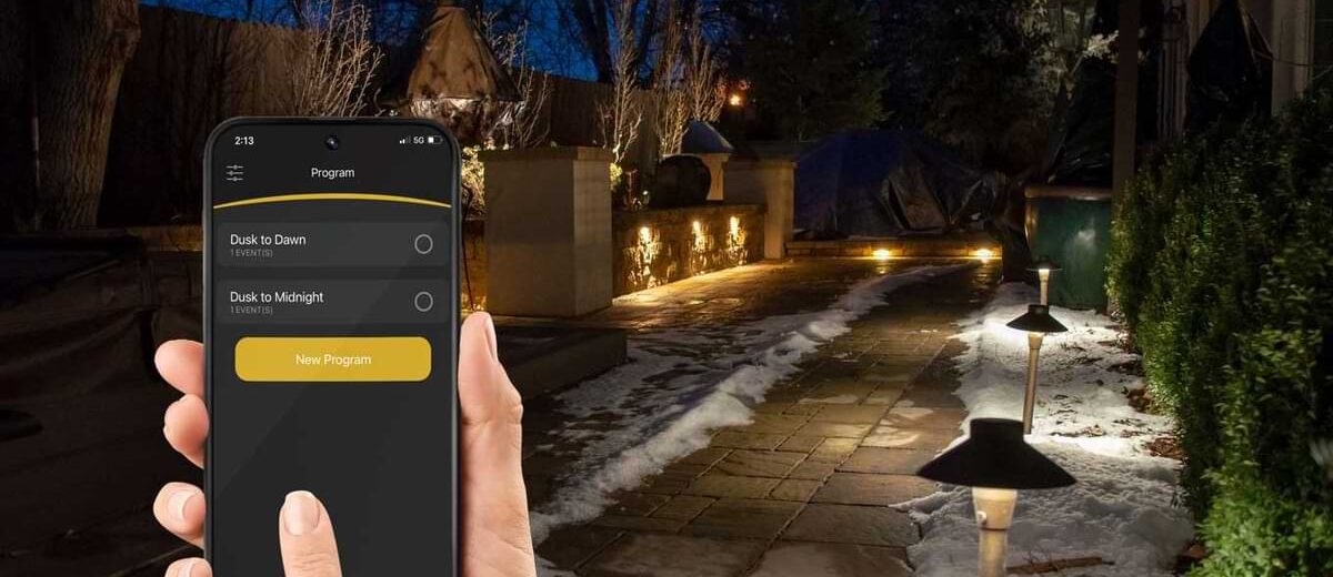 Person controlling landscape lighting with Alliance itPRO app.