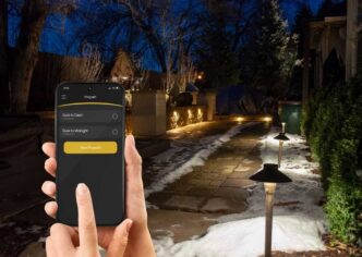 Person controlling landscape lighting with Alliance itPRO app.